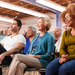 Photo of a diverse group of adults listening to a speaker