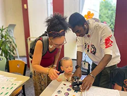 two teens and a little boy making a craft