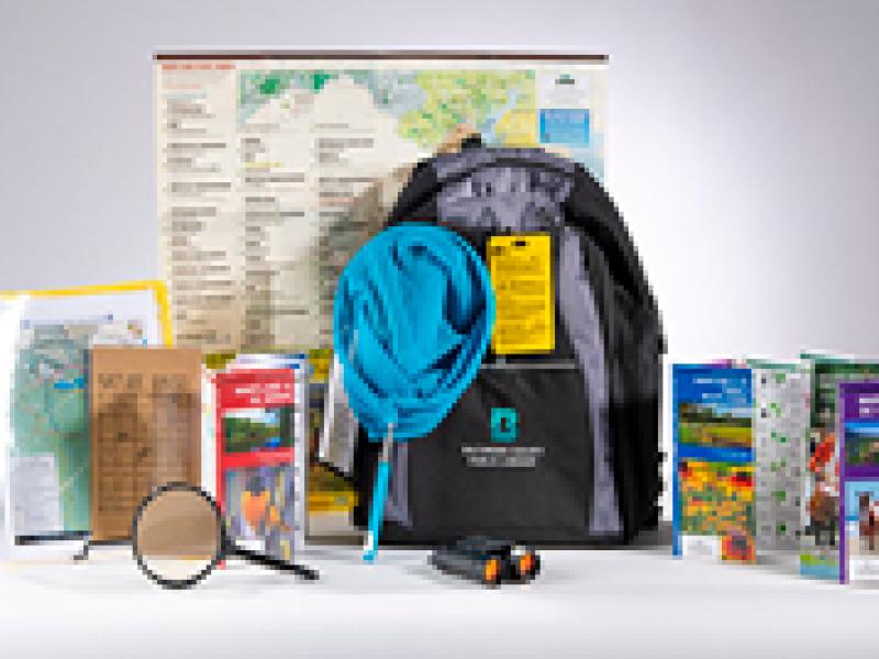 An example of the adventure backpack and some of the items included such as a magnifying glass, dip net and pocket guides.
