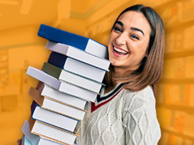 photo of a girl carrying a large stack of books