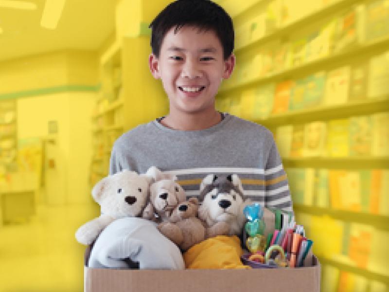 photo of a child holding a box of goods for donation