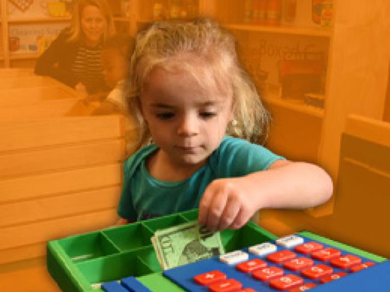 a little girl plays with a toy cash register