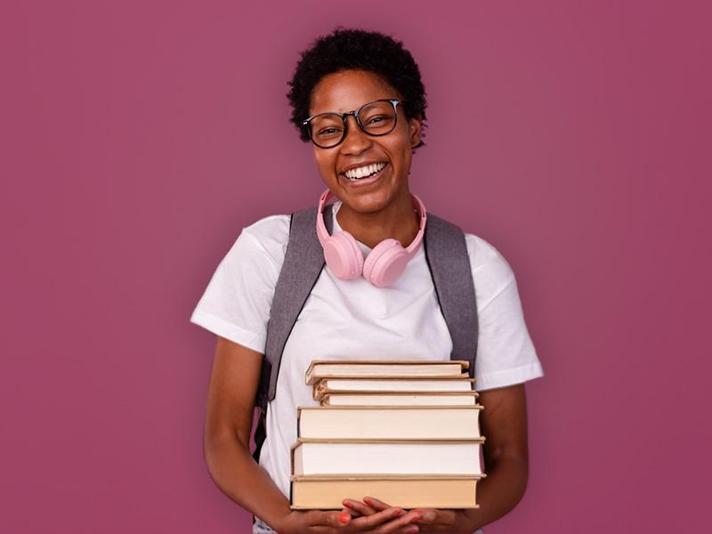Portrait of a woman holding books and wearing headphones