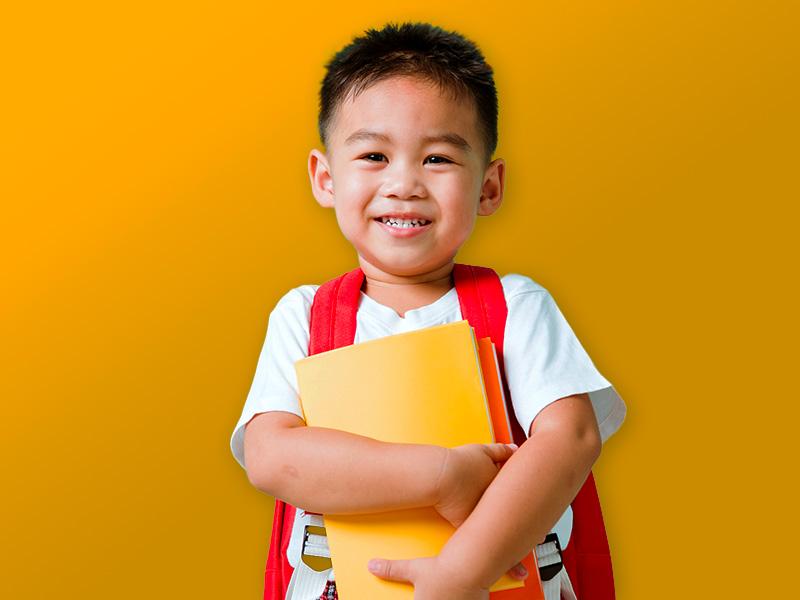 Photo of a child holding school supplies