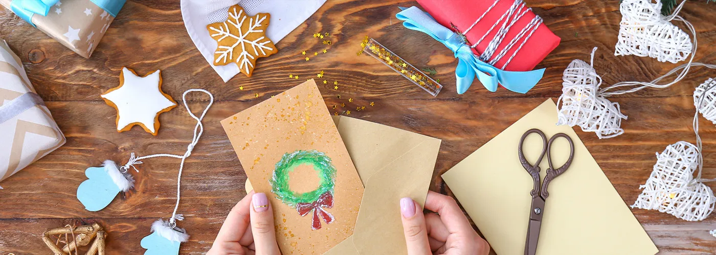 a pair of hands creating holiday cards