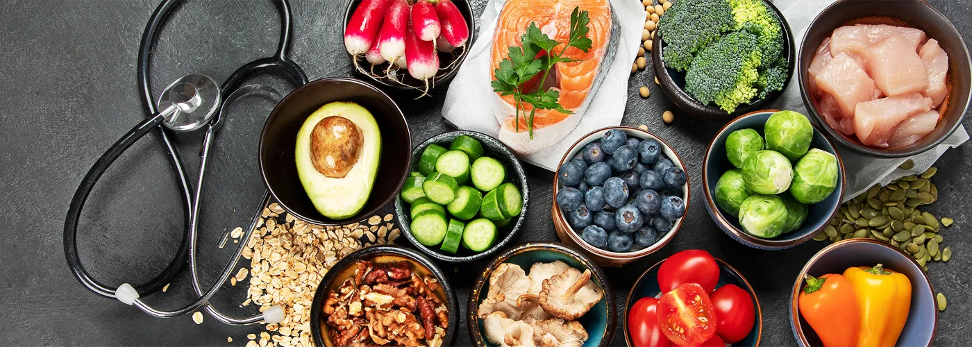 healthy foods in bowls and a stethoscope. 