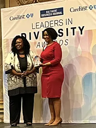 image of two women, one receiving an award