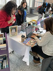 Group of women gathering around a laptop computer
