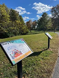 Photo of two signs in a park on a sunny day